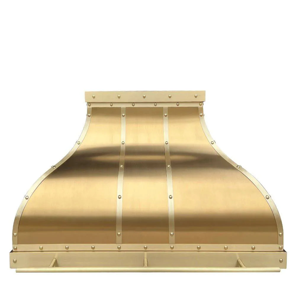 An image of a handcrafted brushed brass range hood with visible rivets and straps, showcasing its sleek design.