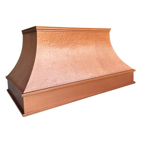 A natural copper range hood with a curved design with light hammered texture.