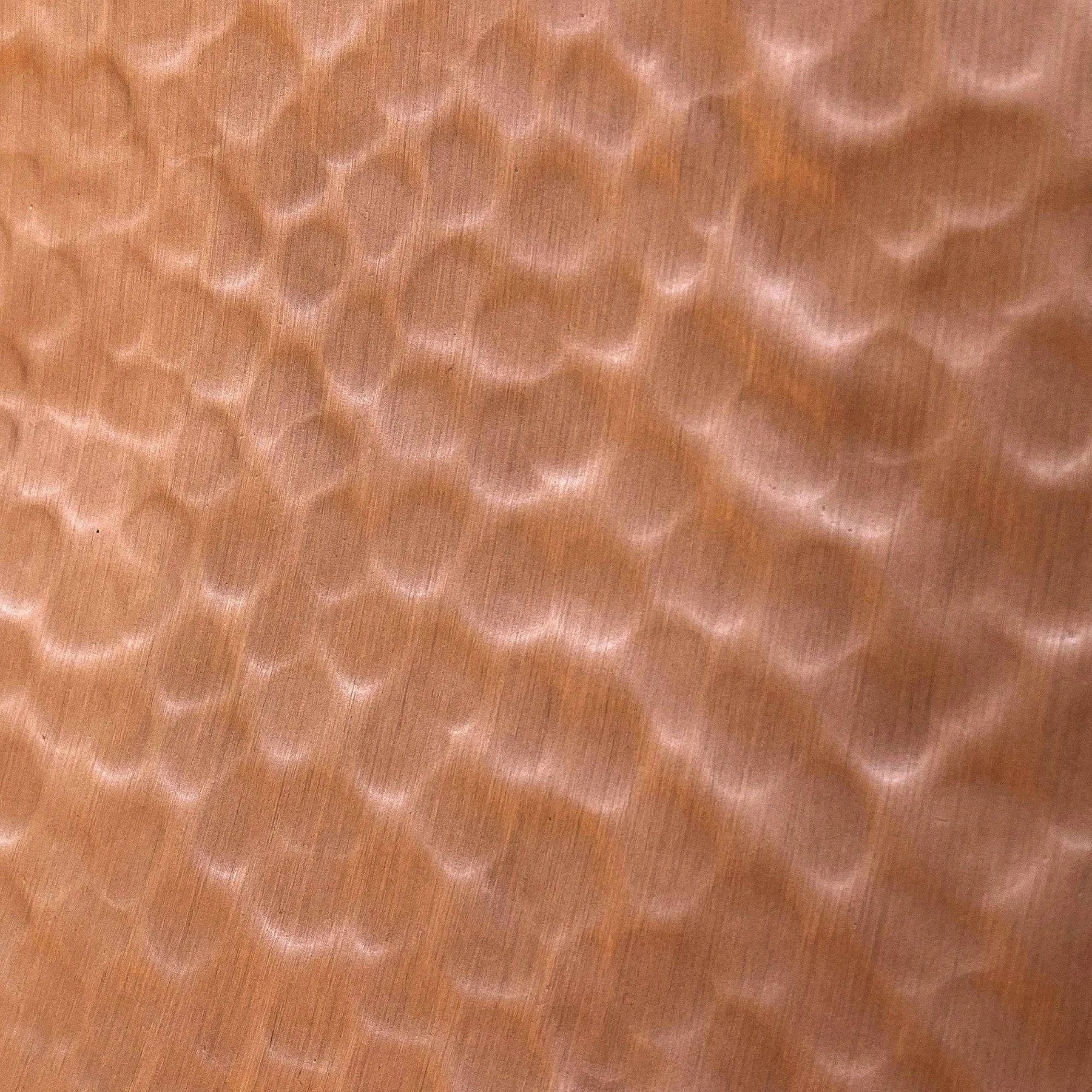A natural copper range hood with light hammered texture.