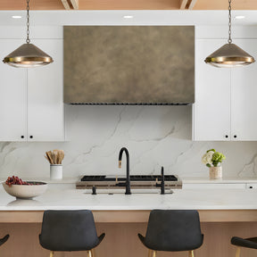 Fobest Custom Retro Brass Range Hood installed in Modern kitchen with marble backsplash and brass pendants.