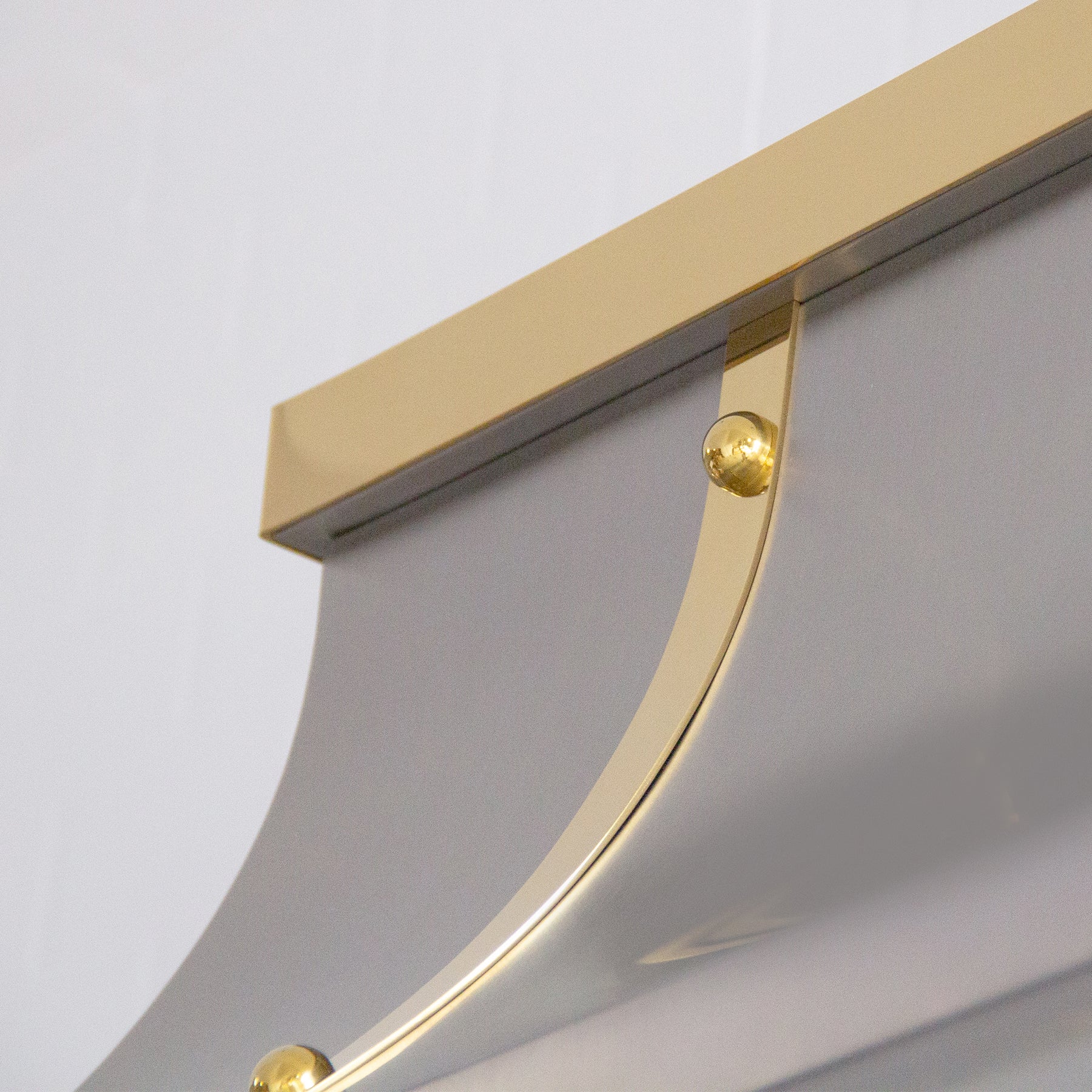 Fobest custom handmade brushed stainless steel range hood with brass straps and rivets installed in the white kitchen